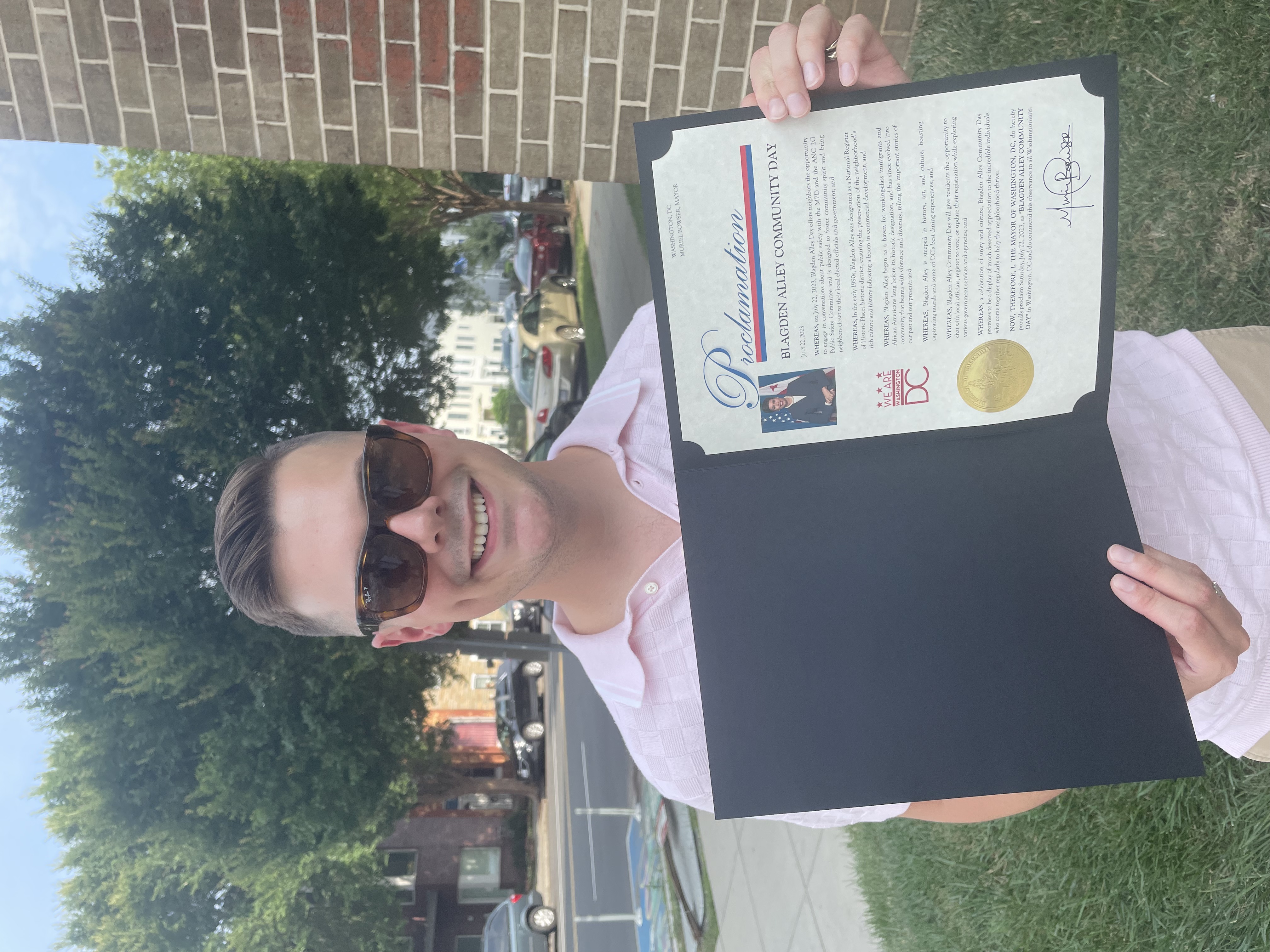Steven holding the Mayor's proclamation of Blagden Alley Community Day